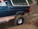 1995 Ford Bronco - This 1995 Ford Bronco is navigating a wet, off-road course with large tires.