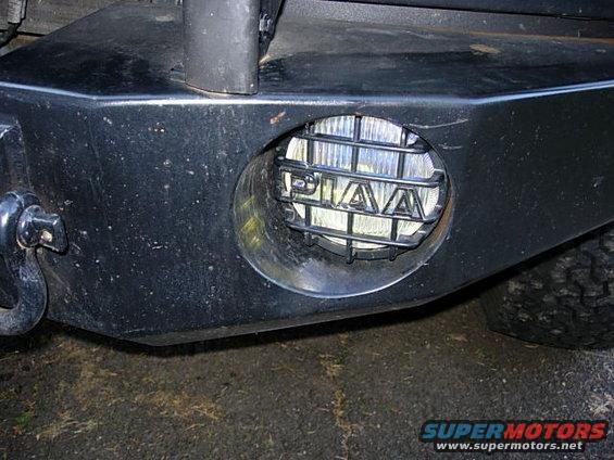 Close-up of aftermarket bumper with PIAA fog light and tow hook