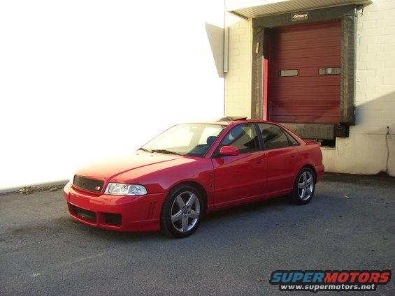Red 1997 Audi A4 parked by a loading dock