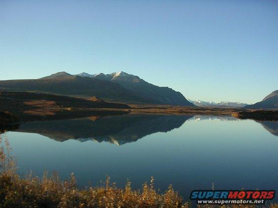 Scenic mountain lake reflection under a clear blue sky