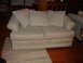 1996 Ford Bronco - A sofa with striped upholstery and cushions sits on a wooden floor next to a rug.