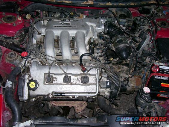 Ford V6 engine with intake manifold and wiring visible. Supermotors.net logo at bottom right