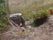 1990 Ford Bronco - This off-road vehicle appears to be stuck in a challenging muddy terrain, tilted precariously.