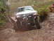 1990 Ford Bronco - Modified Toyota pickup truck tackling a challenging muddy off-road course.