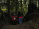 1990 Ford Bronco - A red Jeep Wrangler navigates a muddy, wooded trail with a person observing.
