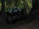 1990 Ford Bronco - A modified Jeep navigates a challenging off-road trail through a dense forest.