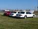 1997 Mercury Grand Marquis - Three 1997 Mercury Grand Marquis sedans are parked on a grassy field under a clear blue sky.
