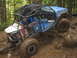 1990 Ford Bronco - This heavily modified buggy navigates a challenging muddy terrain with large off-road tires.