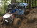 1990 Ford Bronco - This heavily modified buggy navigates a challenging muddy terrain with large off-road tires and a protective roll cage.