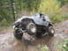 1990 Ford Bronco - A driver maneuvers a modified Jeep Wrangler over challenging terrain on an off-road trail.