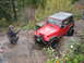 1990 Ford Bronco - Off-roading in a red Jeep Wrangler on a challenging rocky trail.