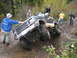 1990 Ford Bronco - A black Ford Bronco navigates a challenging off-road obstacle with several people observing.