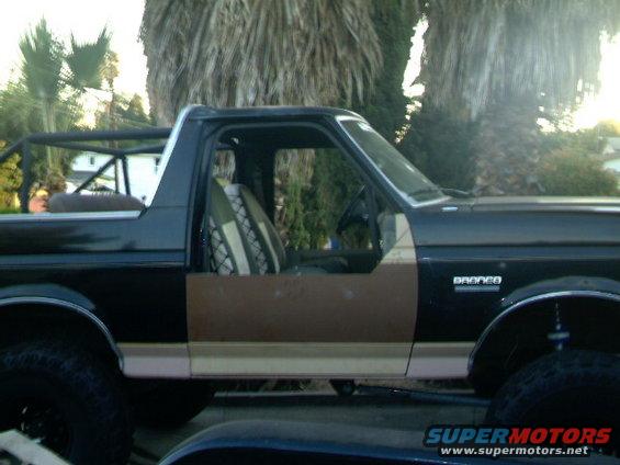 1989 Ford Bronco side view with roll cage and custom seat covers
