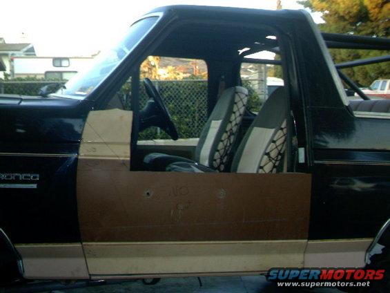 Black Ford Bronco with tan lower body and custom door panels, side view