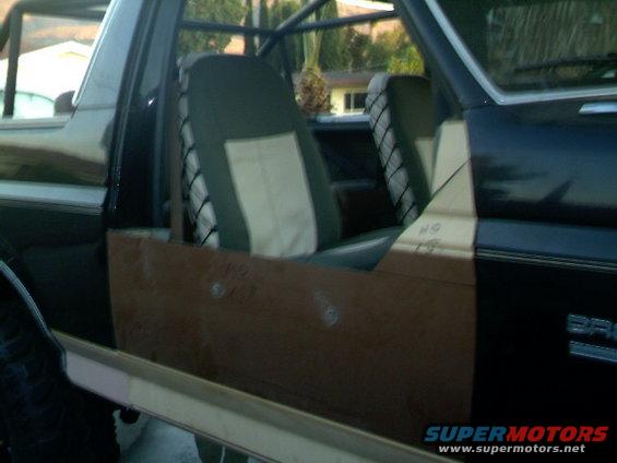 Interior view of a vehicle with custom brown door panels and roll cage