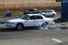 1997 Mercury Grand Marquis - A white 1997 Mercury Grand Marquis performs a burnout at a meet, with a pickup truck and SUV visible in the background.