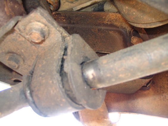 Close-up of a worn suspension bushing on a vehicle's undercarriage