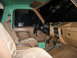 1990 Ford Bronco - The interior of the vehicle shows tan seats and a brown dashboard with some aftermarket accessories attached.