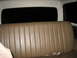 1990 Ford Bronco - The rear bench seat of a vehicle is shown, tan vinyl upholstery and a dark rear window.