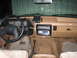 1990 Ford Bronco - The interior of the vehicle shows a tan dashboard with two radios and a CB radio mounted above the dashboard.