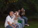 1995 Ford Taurus - A group of men are seated outdoors, engrossed in conversations on their mobile phones.
