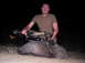 2005 BMW 3 Series - A hunter poses with his javelina kill at night, holding a crossbow.