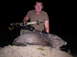 2005 BMW 3 Series - A hunter displays a javelina he has killed, holding a crossbow over the animal.
