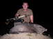 2005 BMW 3 Series - A man poses with a javelina he hunted with a bow and arrow.