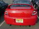 2005 Dodge SRT-4 - Rear view of a red 2005 Dodge SRT-4 sedan parked in a lot. Other vehicles are visible.