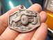 1974 Ford Bronco - This metal charm features a detailed relief of an off-road vehicle, likely a representation of a classic SUV.