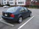 2002 Volkswagen Jetta - A dark blue 2002 Volkswagen Jetta is parked in a lot, showing its rear end and side profile.