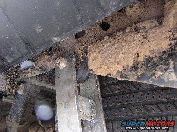 Close-up of rusty underbody frame and tire tread