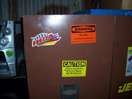 Brown metal cabinet with IHRA Motorsports, Warning, and Caution stickers