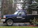 1995 Ford F-250 - This blue 1995 Ford F-250 pickup truck is equipped with a ladder rack and appears to be parked outdoors.