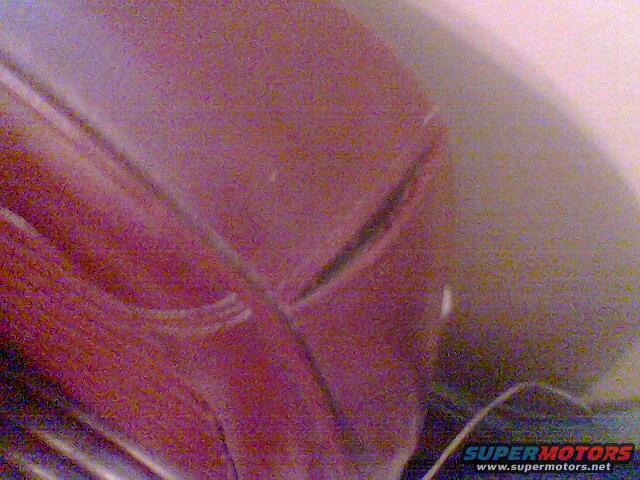 Red car hood detail with a curved seam and reflection