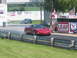 2003 Ford Mustang - A red Chevrolet Corvette is on the drag strip, with another car visible in the background.