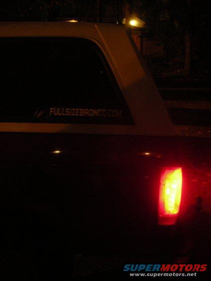 1995 Ford Bronco rear quarter panel with 'FULLSIZEBRONCO.COM' sticker and illuminated taillight