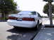 1997 Ford Thunderbird - Rear view of a white 1997 Ford Thunderbird parked curbside on a sunny day.