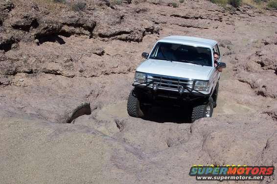 White 1993 Ford Bronco navigating a rocky off-road path