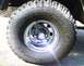 1979 Ford Bronco - A close-up view of a tire and wheel assembly, the Supermotors.net logo on the tire.