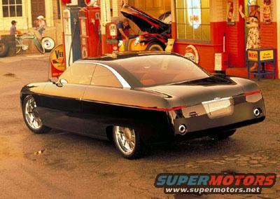 Black custom coupe concept car with chrome wheels parked at a vintage gas station