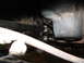 1994 Jeep YJ - Underside view of vehicle steering linkage components, including a black tie rod and gold-colored joints.