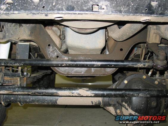 Undercarriage view showing steering linkage, leaf springs, and front differential housing