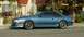 1988 Ford Mustang - A blue 1988 Ford Mustang coupe is seen from the side, aftermarket wheels and a hood scoop.