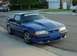 1988 Ford Mustang - Blue 1988 Ford Mustang parked on a street, showing its front 3/4 view with an aftermarket hood.