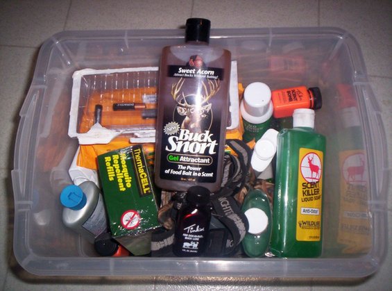 Plastic bin filled with hunting supplies including Buck Snort attractant, ThermaCELL mosquito repellent refills, and Scent Killer liquid soap