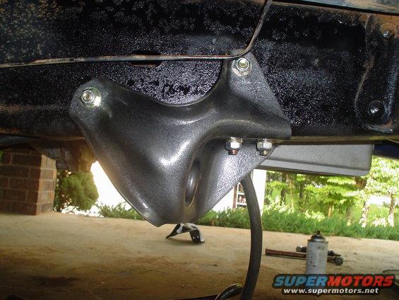 Gray lift kit bracket bolted to black vehicle frame, with "SUPERMOTORS" logo visible