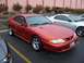 2002 Ford Mustang - A red 1994 Ford Mustang is parked next to a silver vehicle.
