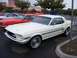 2002 Ford Mustang - A white 1967 Ford Mustang is parked in a lot with other classic cars.