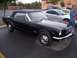 2002 Ford Mustang - A black convertible classic car is parked next to a silver modern car.